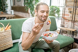 man eating healthy foods on a couch