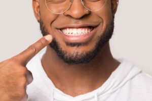 closeup of a man pointing to his smile